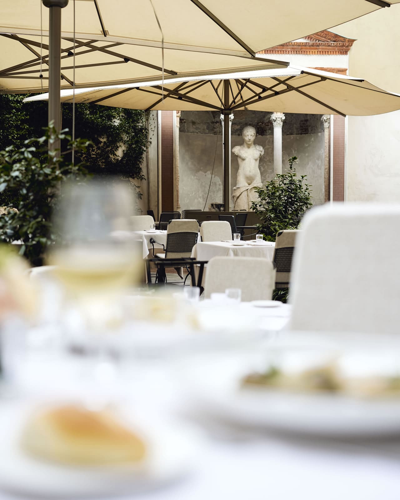 Lush garden setting with elegant tables at Paper Moon Giardino in Milan Lush garden setting with elegant tables at Paper Moon Giardino in Milan